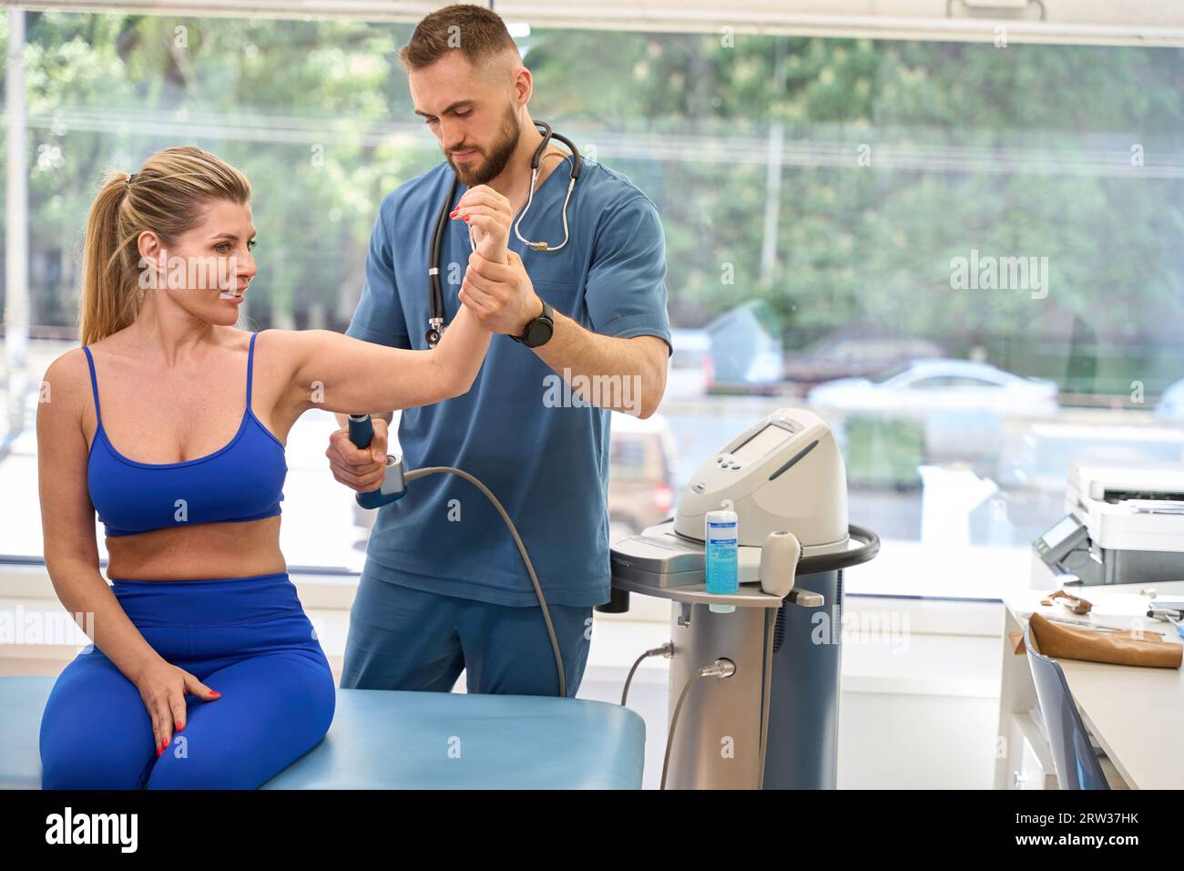 Skilled orthopedist performing trigger point therapy on female client forearm Stock Photo