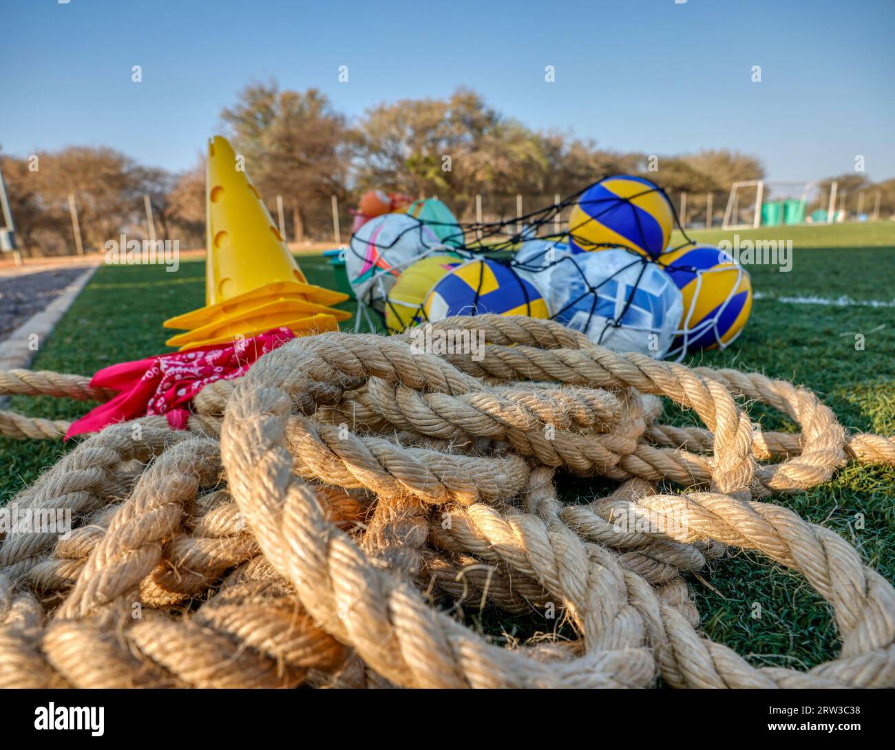 tangled rope for the thug of war games and balls in a net next to a cone ready to be used by the participants Stock Photo
