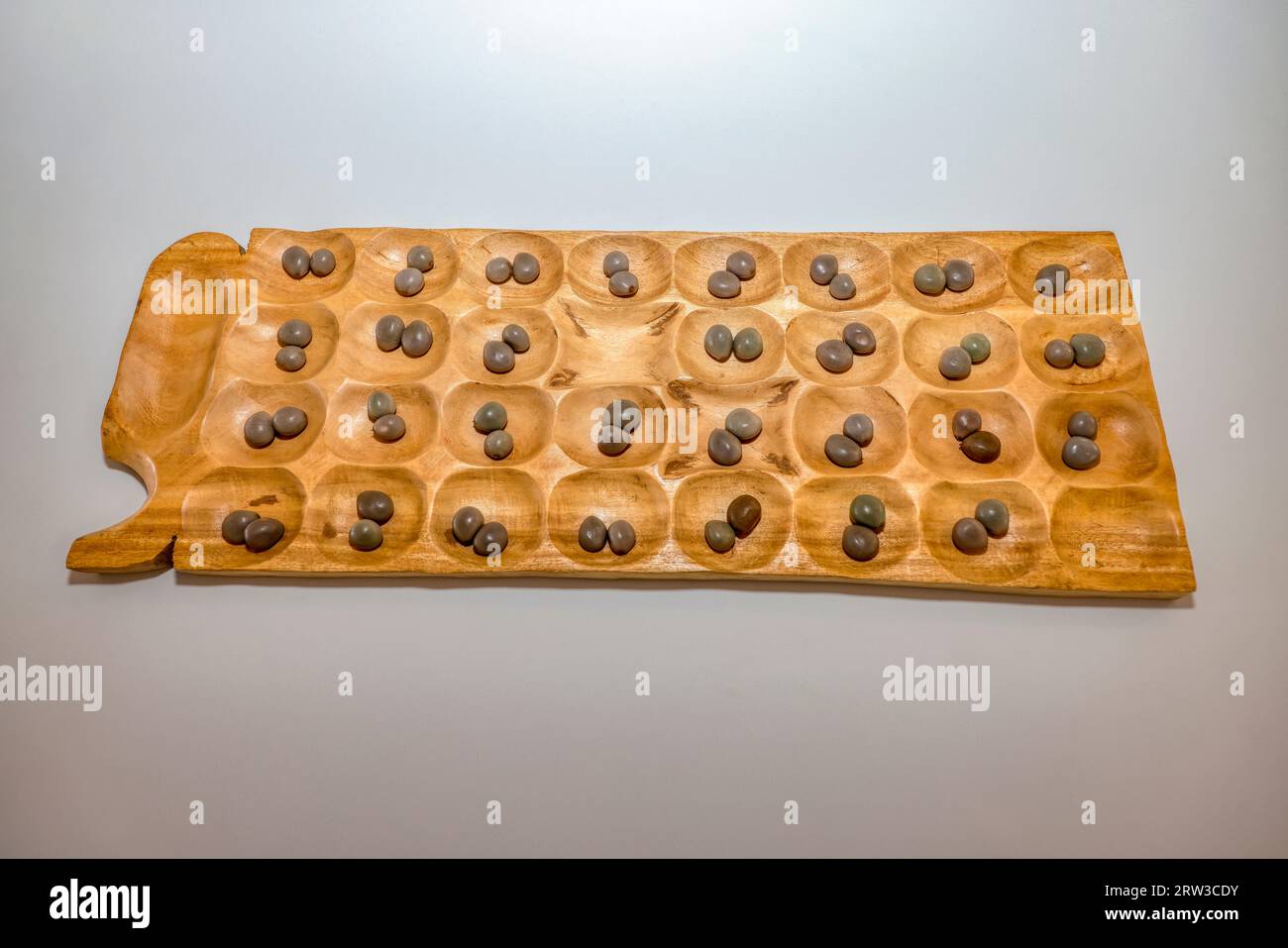 Mancala african board game made out of wood played with rock marbles, two-player turn-based strategy board games played with small stones, beans, or s Stock Photo