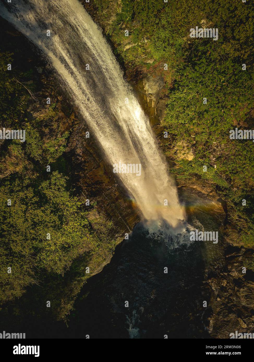 Aerial view of a majestic waterfall cascading down a lush, tropical ...