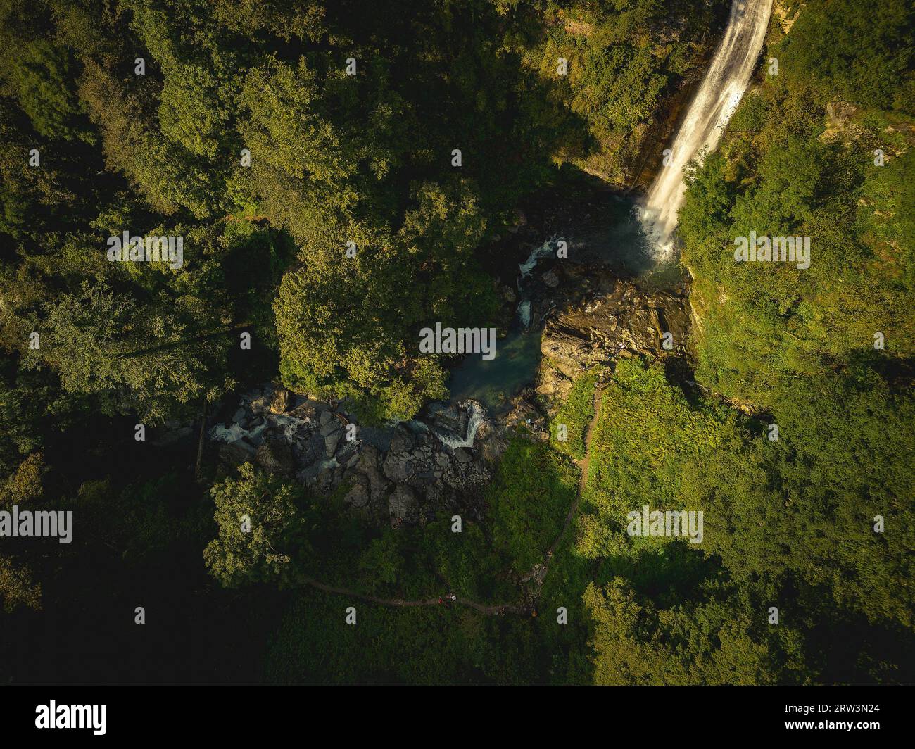 Aerial view of a majestic waterfall cascading down a lush, tropical ...