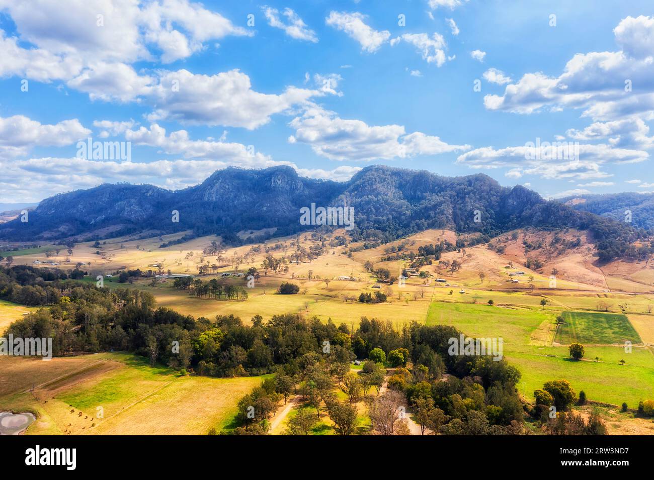 Green pastures of cattle farms aroudn Gloucester town at Barrington tops mountains in Australia - aerial landscape. Stock Photo