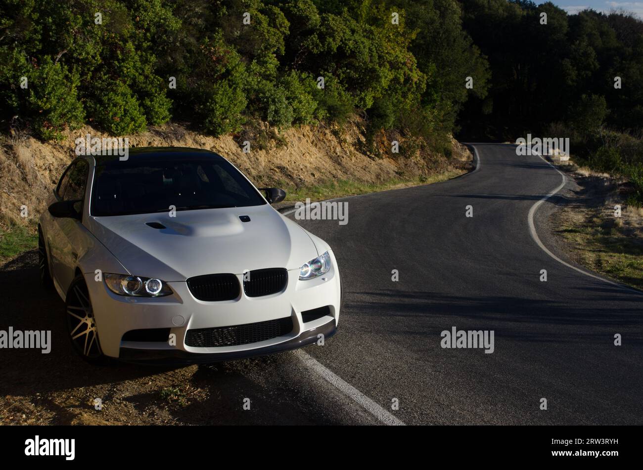 German luxury sport coupe on the shoulder of a curving mountain road Stock Photo