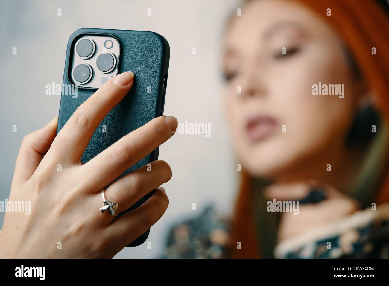 Attractive woman posing takes selfie on iPhone 13 pro. Stock Photo