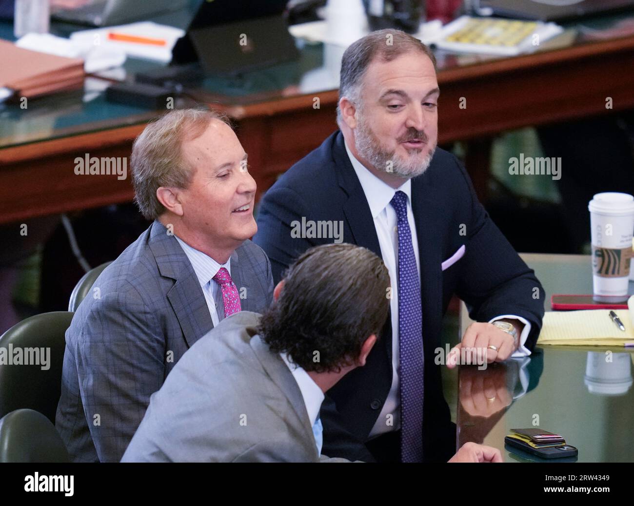 Austin, Texas, USA. 16th Sep 2023. Texas Attorney General KEN PAXTON smiles while he sits sits with his lawyers TONY BUZBEE and MITCH LITTLE before testimony on September 15, 2023. Paxton will be reinstated as Texas Attorney General after surviving an impeachment vote on 16 counts in the Texas Senate on September 16, 2023. Paxton did not attend the final day of the trial. Credit: Bob Daemmrich/Alamy Live News Stock Photo