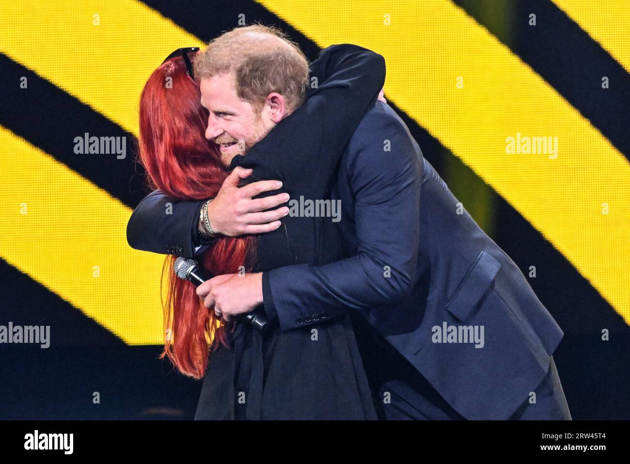 Düsseldorf, Germany. 16th Sep, 2023. Prince Harry, the Duke of Sussex, hugs a Ukrainian daughter of a female soldier, then kspeaks at the ceremony. The Invictus Games Düsseldorf conclude with a closing ceremony at Merkur Spiel Arena. 21 nations participated in the games this year. Athletes parade around the arena and participate, and there are performances from singers Sam Ryder and Rita Ora, as well as speeches from Prince Harry, German President Steinmeyer and other dignitaries. Credit: Imageplotter/Alamy Live News Stock Photo