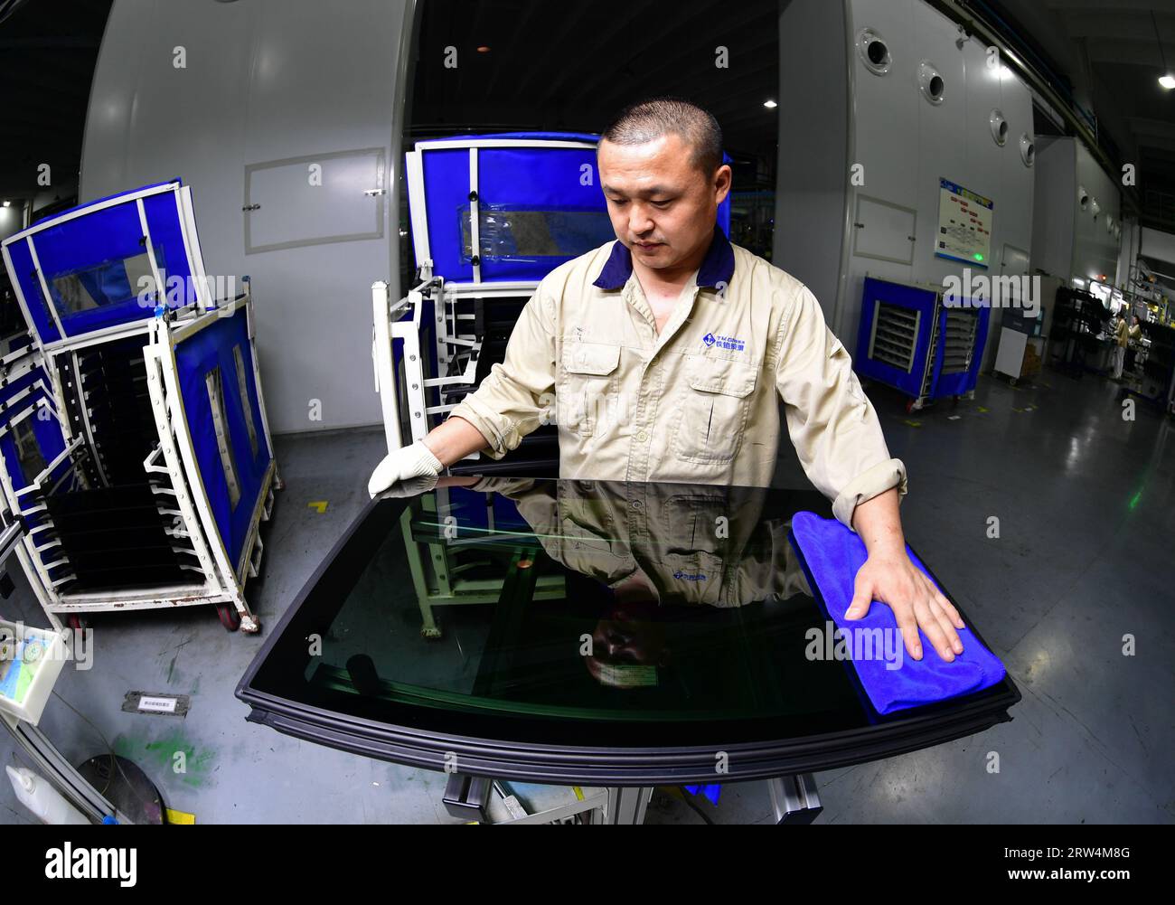 A worker produces sunroof glass for new energy vehicles on an