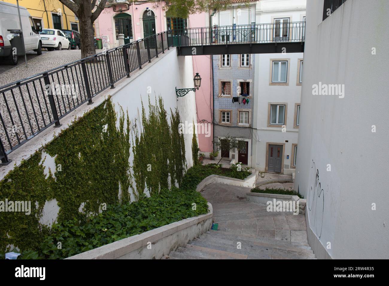 City stairs going down and footbridge above in old part of Lisbon in Portugal Stock Photo