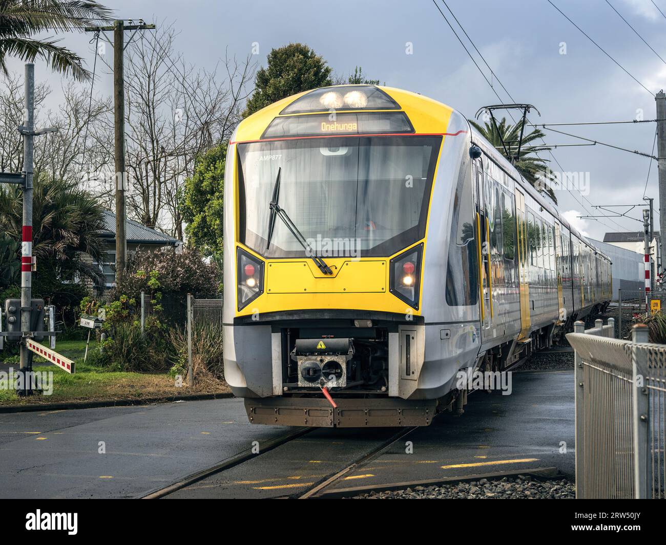 Auckland Transport Kiwirail electric train at rail crossing in Onehunga