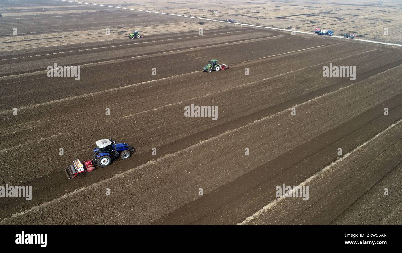 Farmers drive tractors to level up land, North China Stock Photo - Alamy