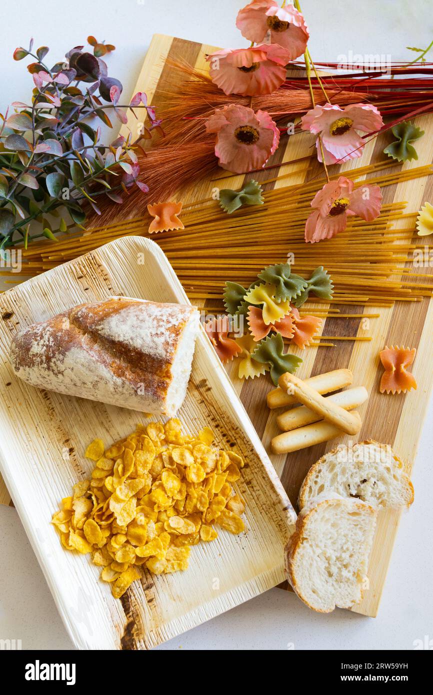 Foods to avoid for celiac disease sufferers: bread, pasta and cereal. Gluten, diet and wheat products concept. Decorated with dried flowers. Stock Photo