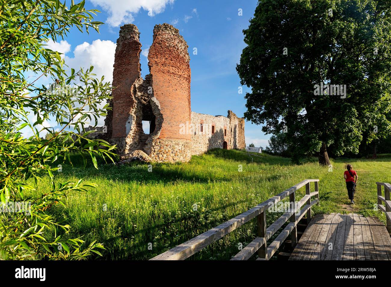 Tourist exploring ruins of a Laiuse Castle on a beautiful sunny summer day in Estonia Stock Photo