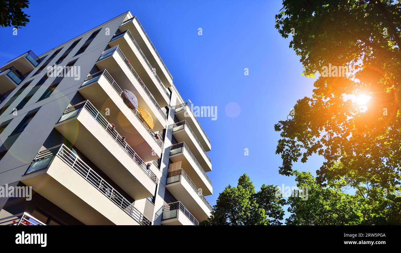 Image showcasing Modern apartment building and green trees. Ecological housing ...