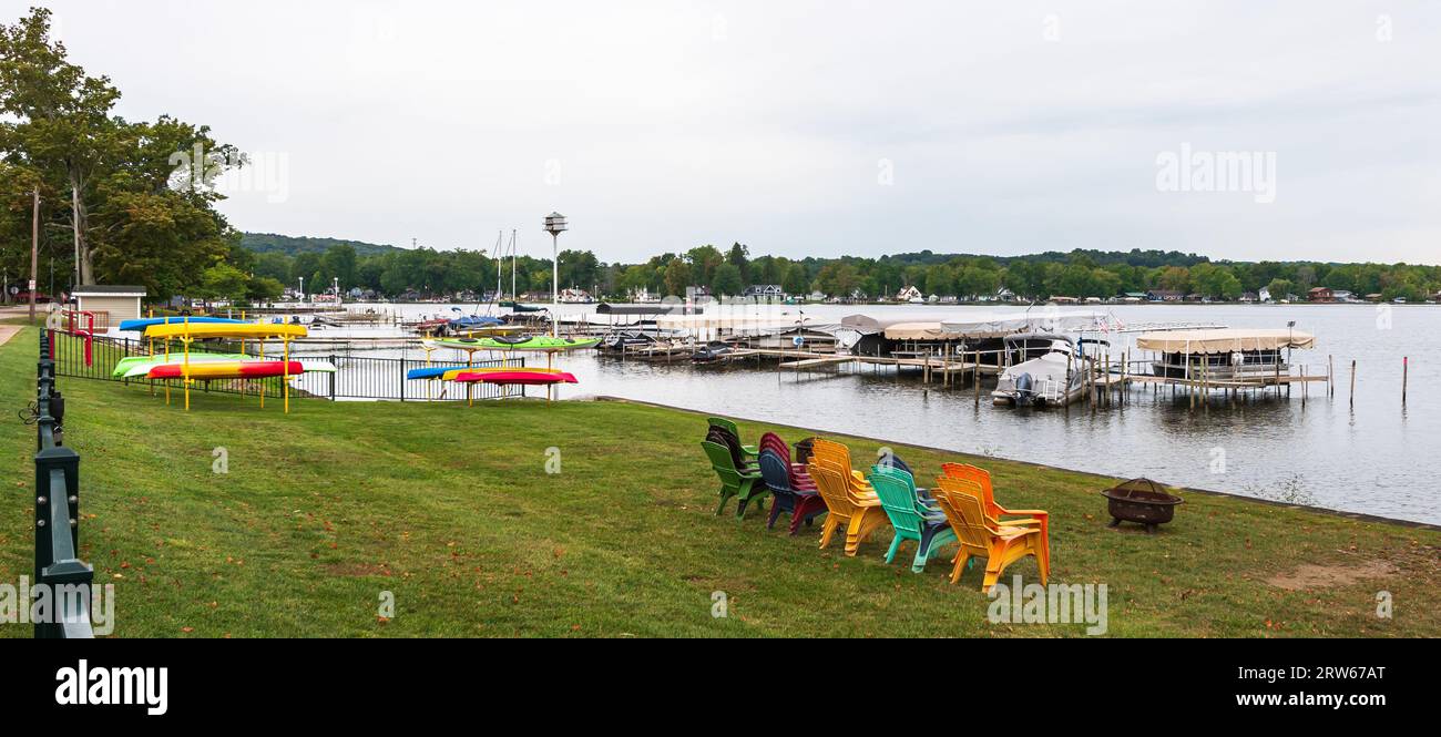Chairs and kayaks stacked along Lake Chautauqua with a pier in the