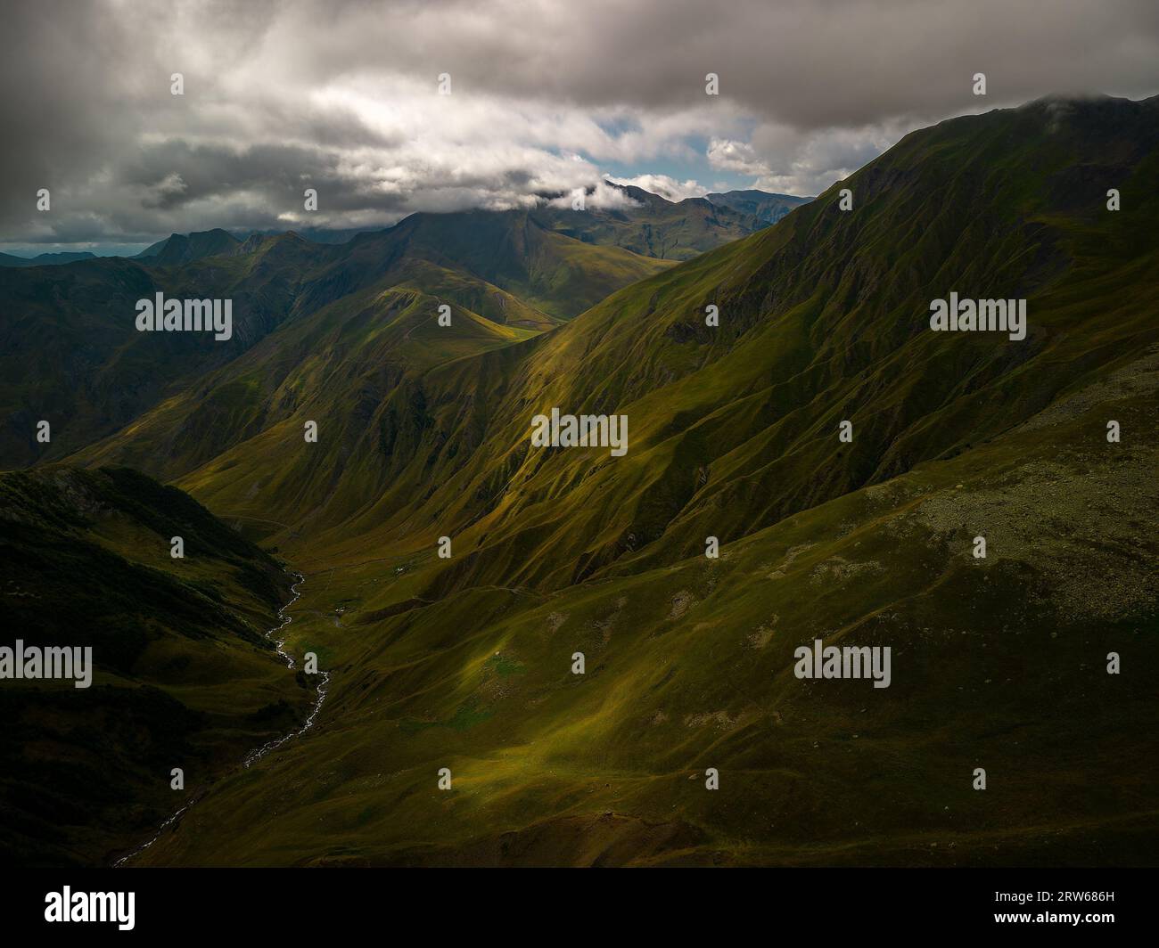 A stunning mountain range with rolling hills and lush green grass ...