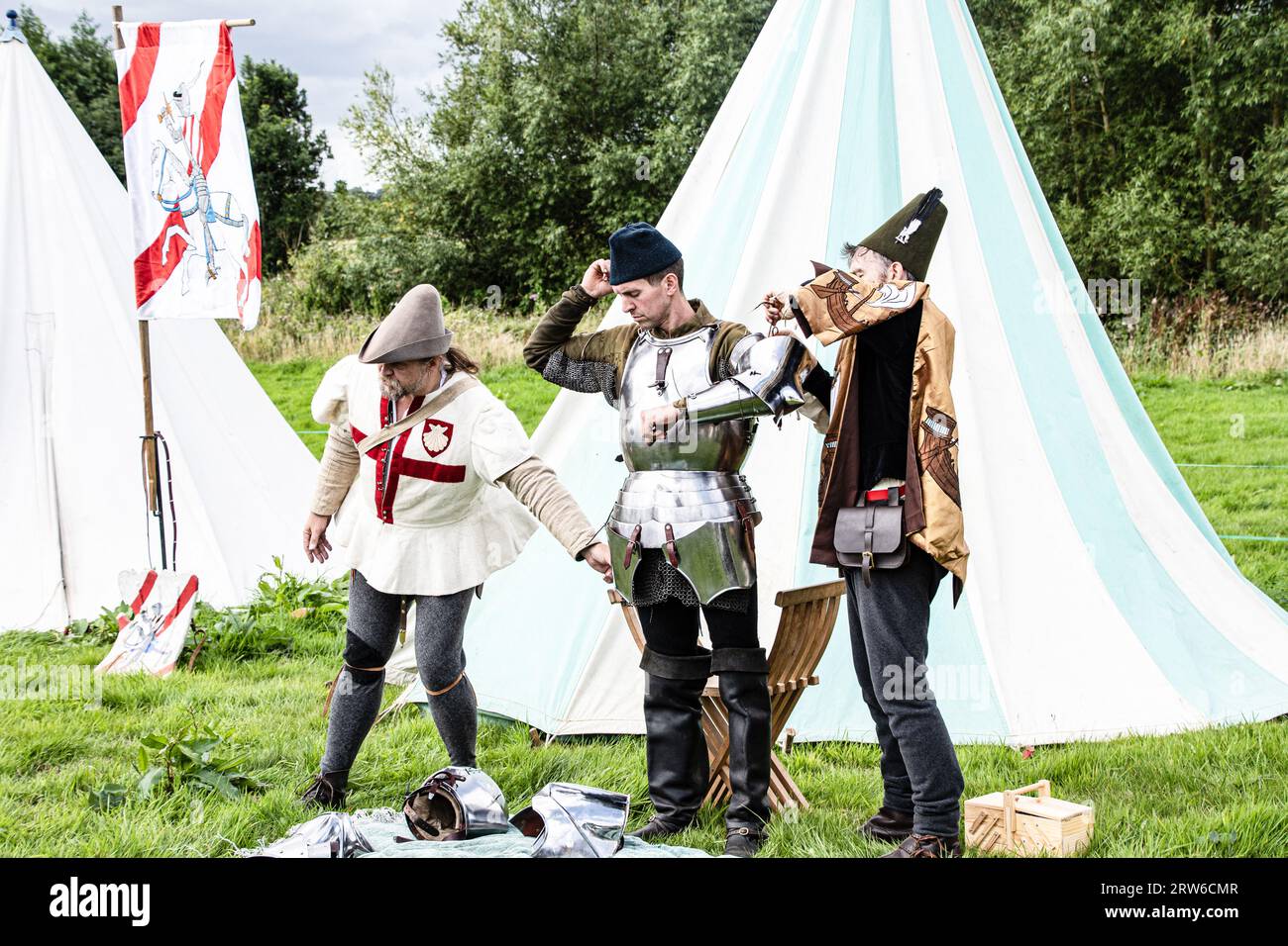 Kenilworth England July 29th 2023 A squire  is  arming  his  knight the  Wyvern  At  Kenilworth castle  fixing  his  armour  in to  place ready  for Stock Photo