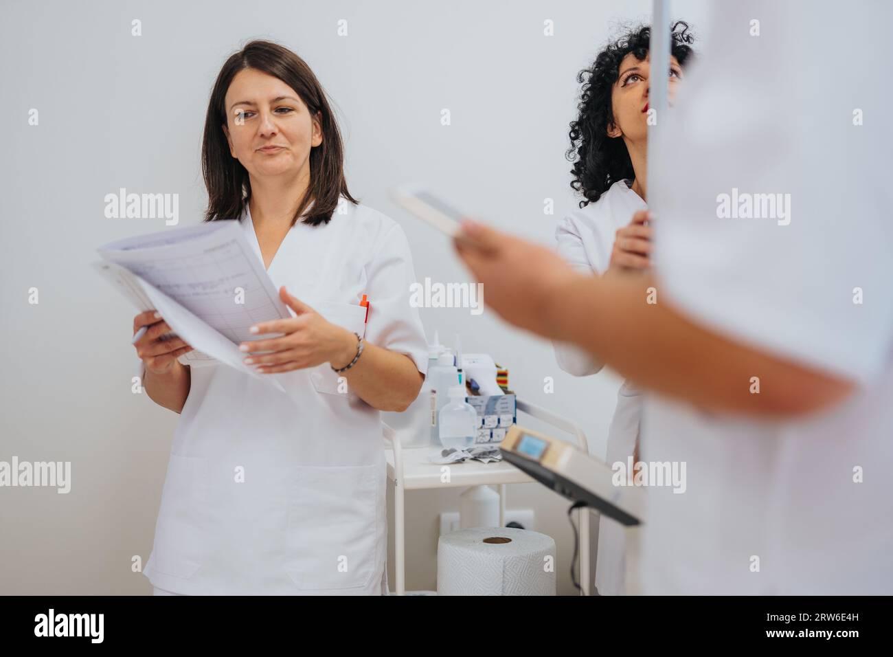 A female doctor conducts medical examinations and checks a patient's height in a hospital examination room. Expert care and special attention ensure q Stock Photo