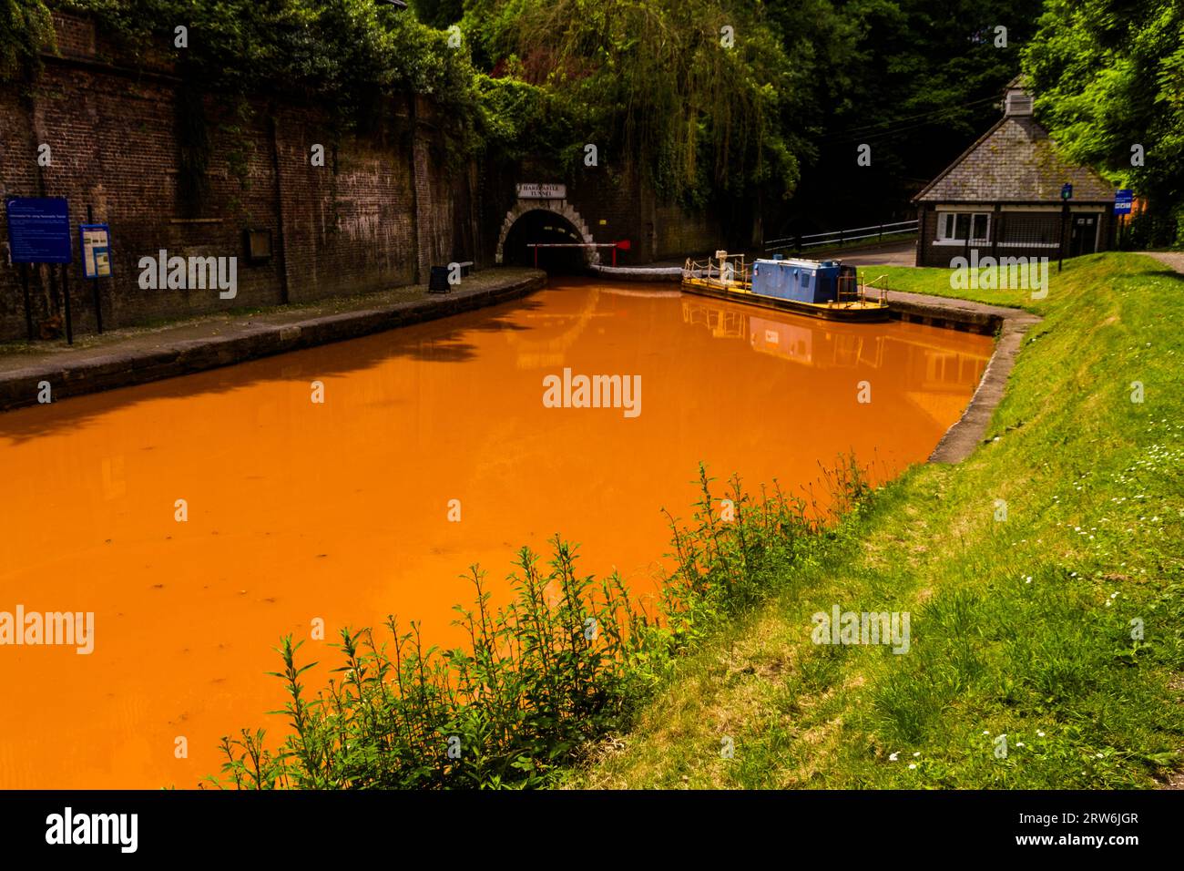 The Trent and Mersey Canal and northern entrance to the Harecastle Tunnel, Kidsgrove, Newcastle-under-Lyme. The water is orange because if clay deposi Stock Photo