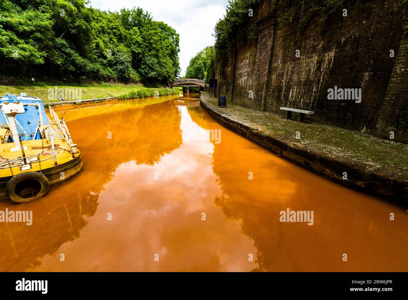 The Trent and Mersey Canal, Kidsgrove, Newcastle-under-Lyme. The water is orange because if clay deposited in the Harecastle Tunnel, landscape, wide a Stock Photo