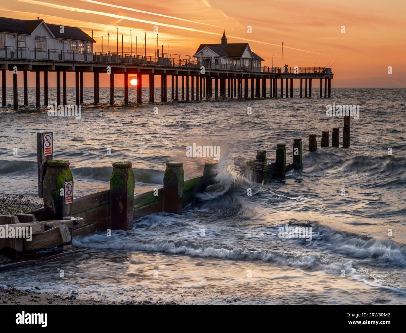 Friday 15th September 2023. Southwold, Suffolk, England - The sun rises behind the distinctive pier at Southwold at the start of another warm late sum Stock Photo