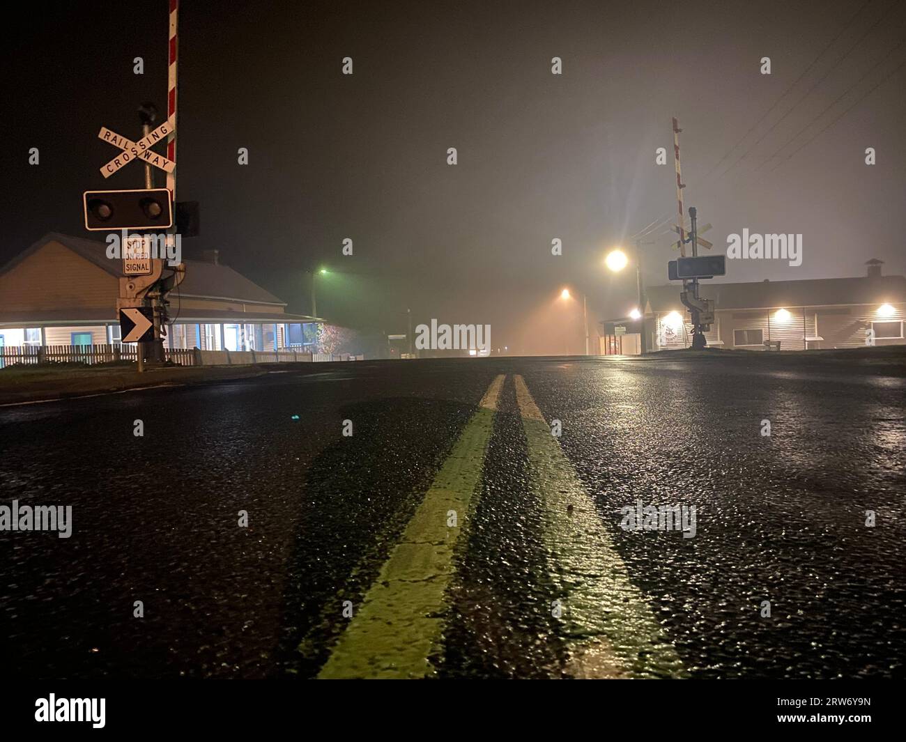 A closeup of a CaptionRailway crossing across Vasse Highway on rainy