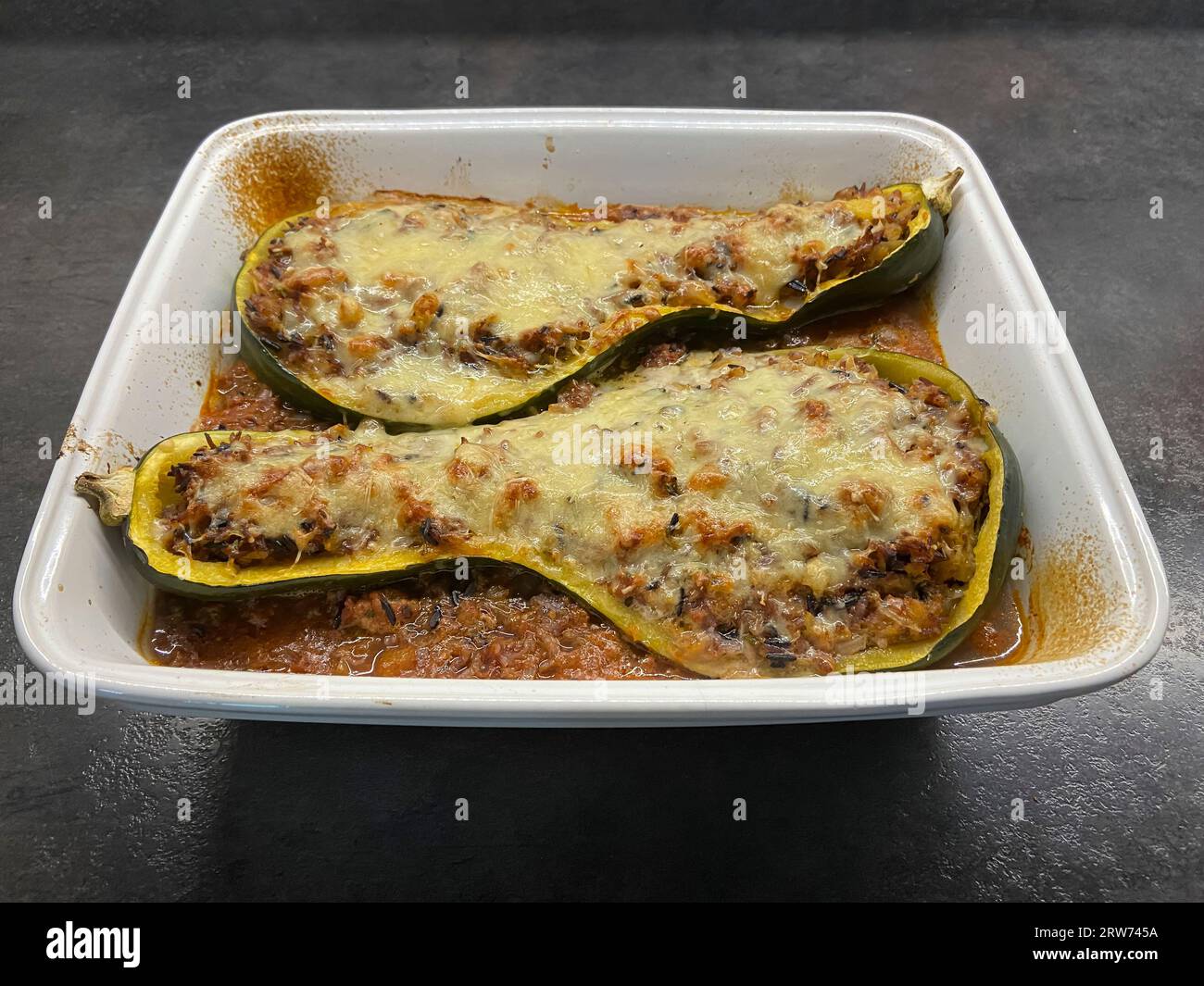 Stuffed zucchini recipe. A cooked dishe with zucchini cut in half, filled with zucchini pulp