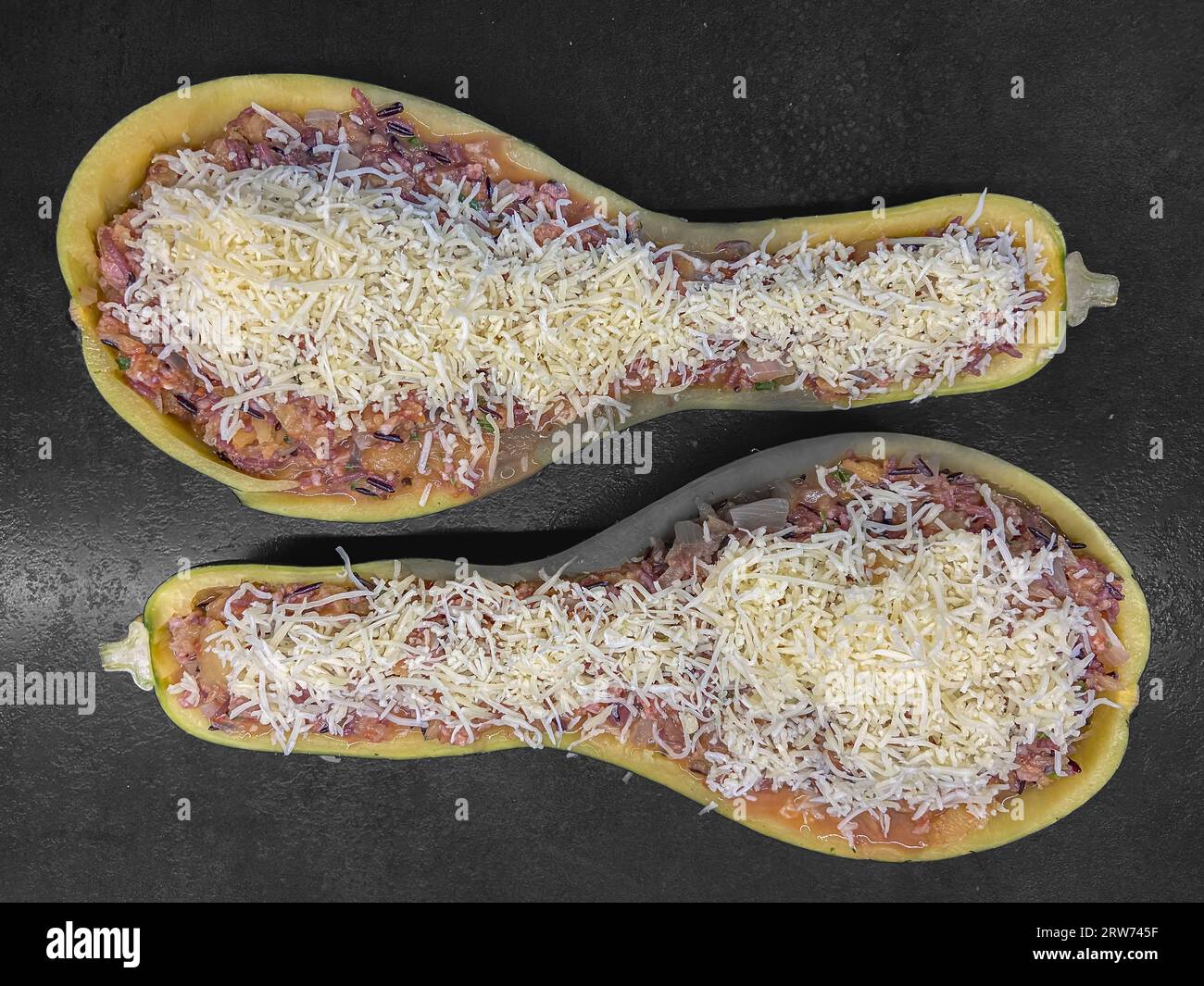 Stuffed zucchini recipe. A zucchini cut in half, filled with zucchini pulp, black and white rice
