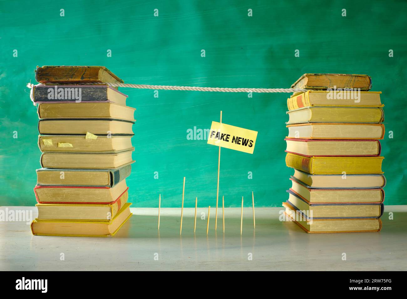 Fight fake news, education,learning,knowledge,back to school,media literacy concept with slackline and stacks of books, free copy space Stock Photo