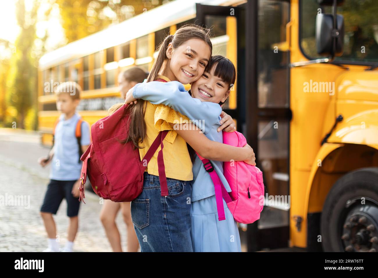 Portrait Of Two Happy Girls Embracing While Standing Outdoors Near ...