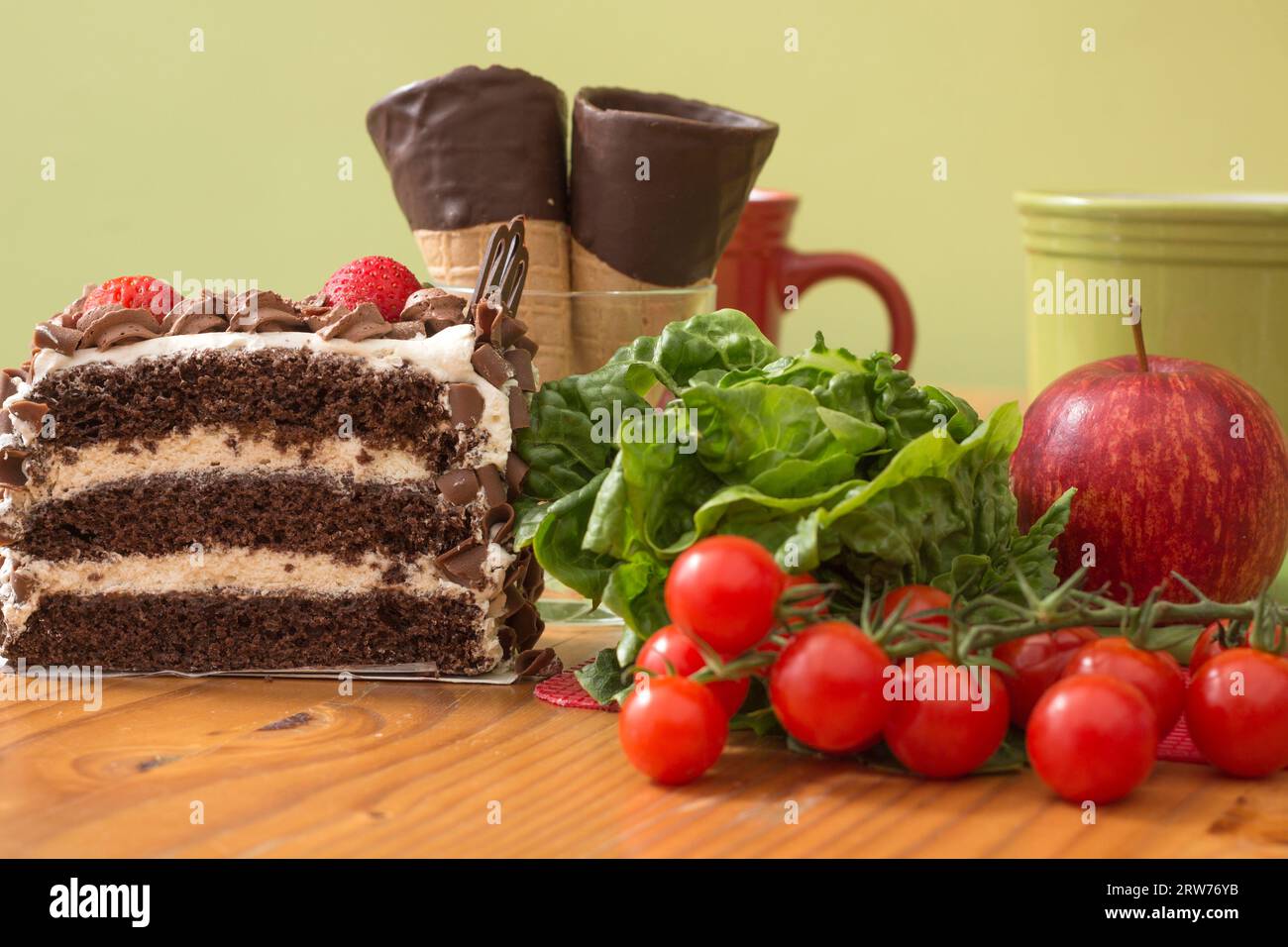 Healthy eating versus an unhealthy choice of chocolate layer cake Stock