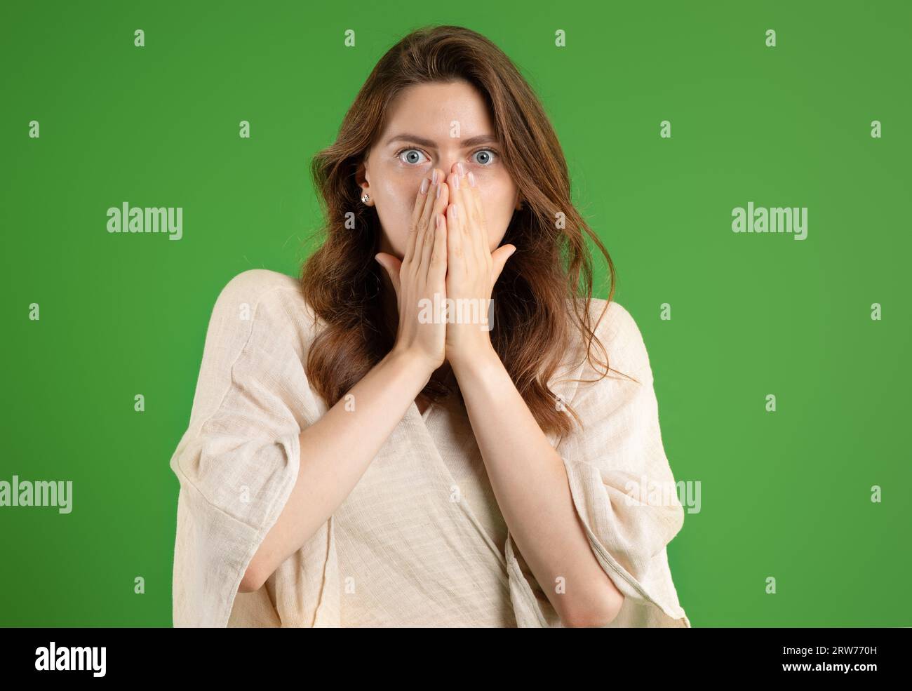 Scared young european lady in casual covers face with hands, isolated ...