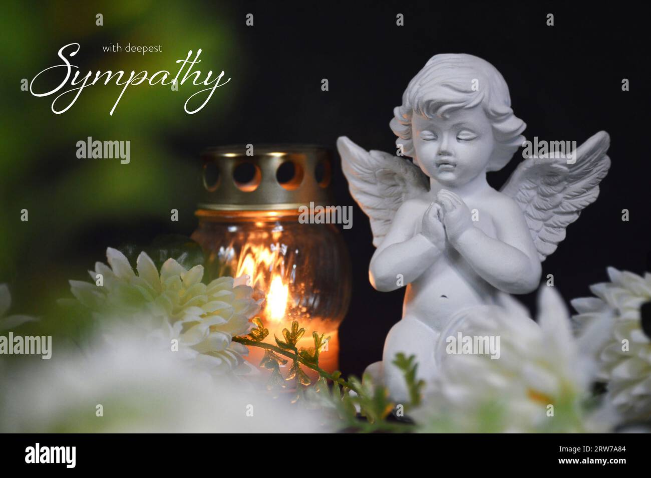 Sympathy card with an angel, votive candle and flowers on black background Stock Photo
