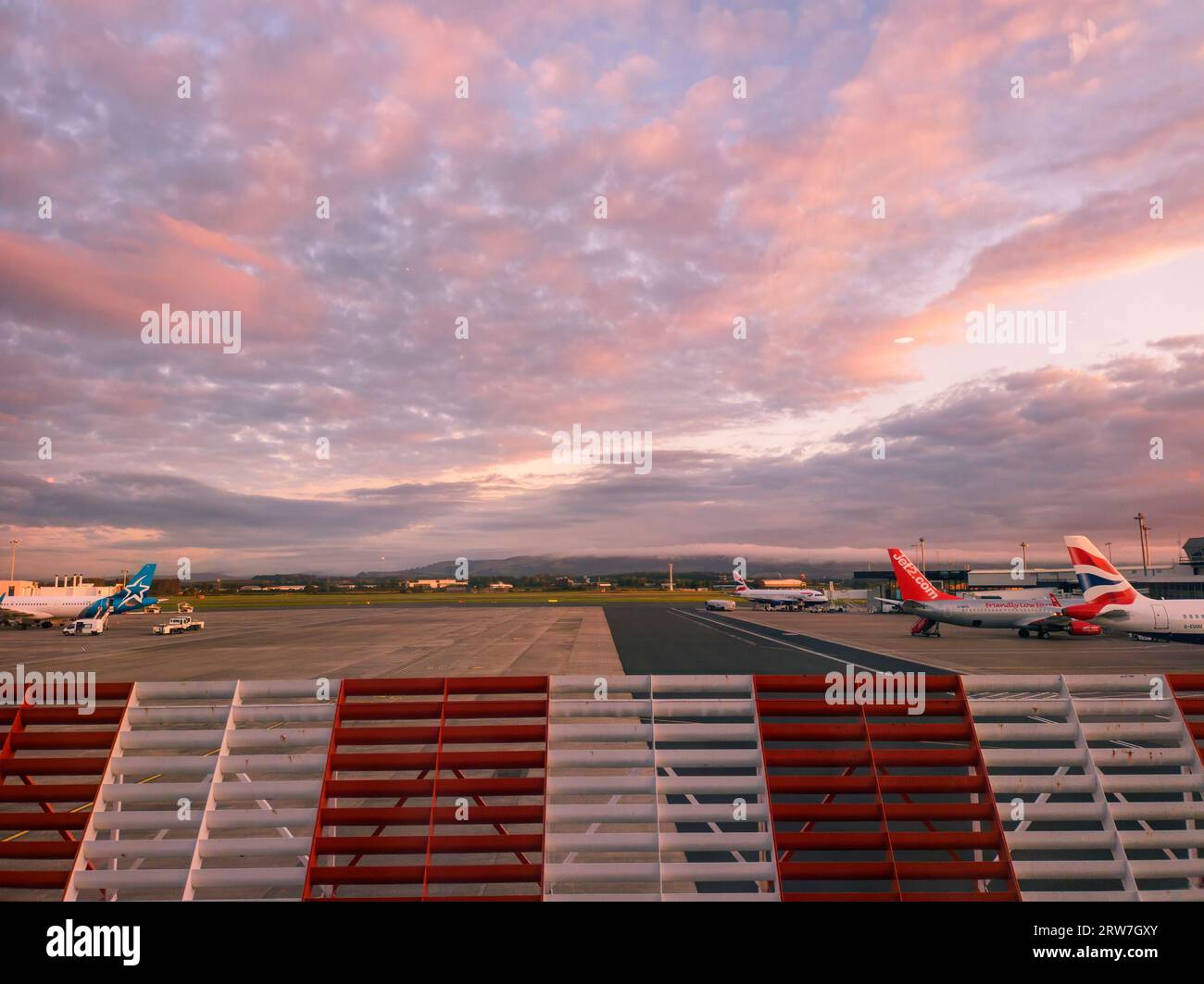 A colourful sunrise sky over Glasgow International Airport in Scotland Stock Photo