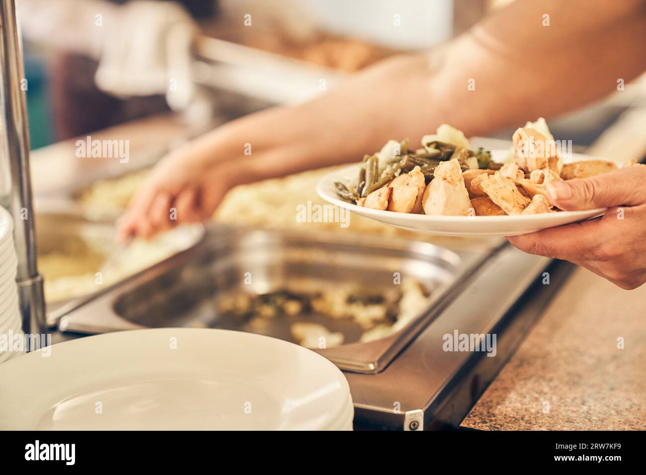 A hand serving food to the homeless. People receiving donations from a good friend, the concept of careful giving. High quality photo Stock Photo