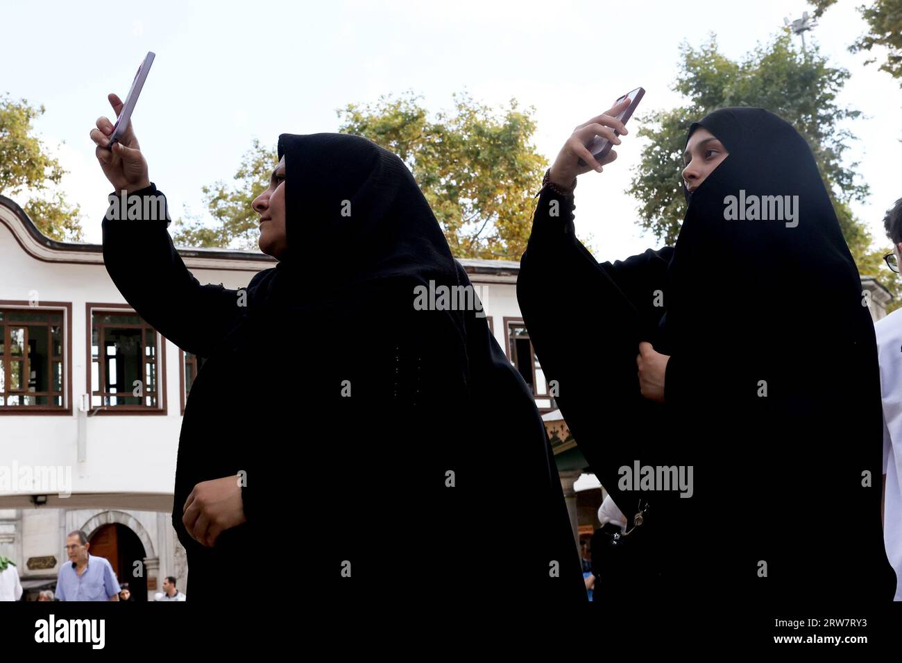 Muslim women, each wearing a burqa, taking selfies with their smartphones at the Eyüp Sultan Mosque in Istanbul Turkey Stock Photo