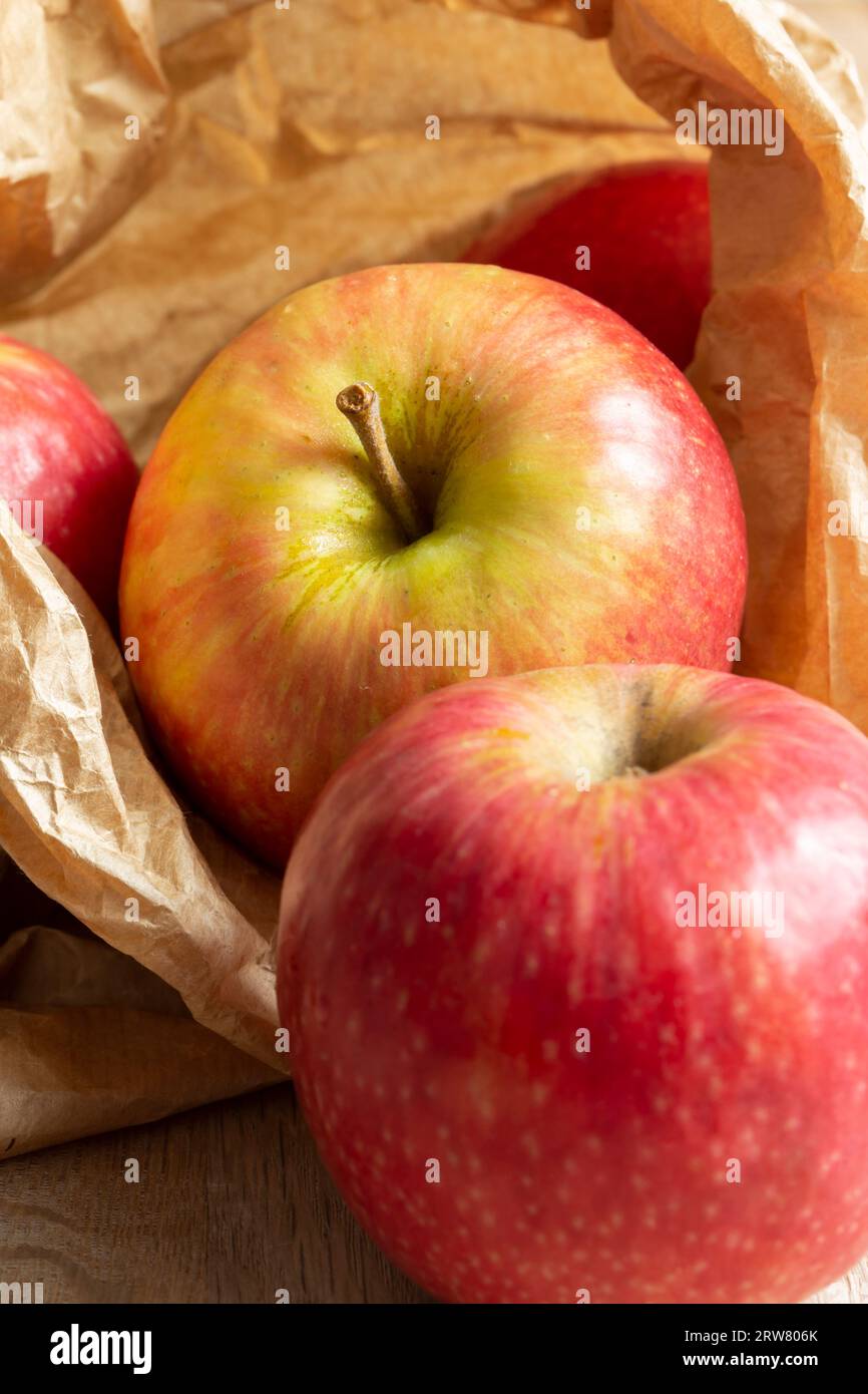 https://c8.alamy.com/comp/2RW806K/apples-pink-lady-variety-in-a-brown-paper-bag-on-a-wood-background-environmentally-friendly-packaging-concept-2RW806K.jpg