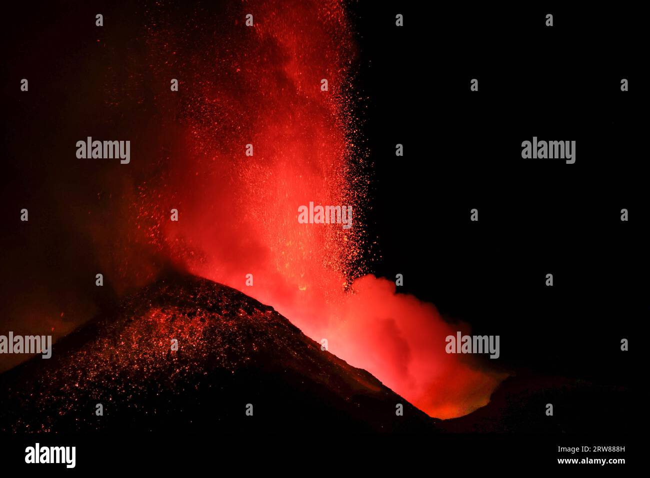 Etna ravvicinato e dettagliato della grande eruzione lavica notturna sulla silhouette del cratere retroilluminato dalla lava Stock Photo