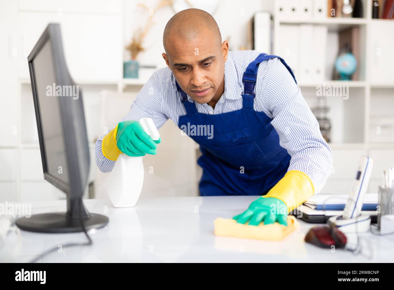 Latin cleaner at work in office near computer desk Stock Photo