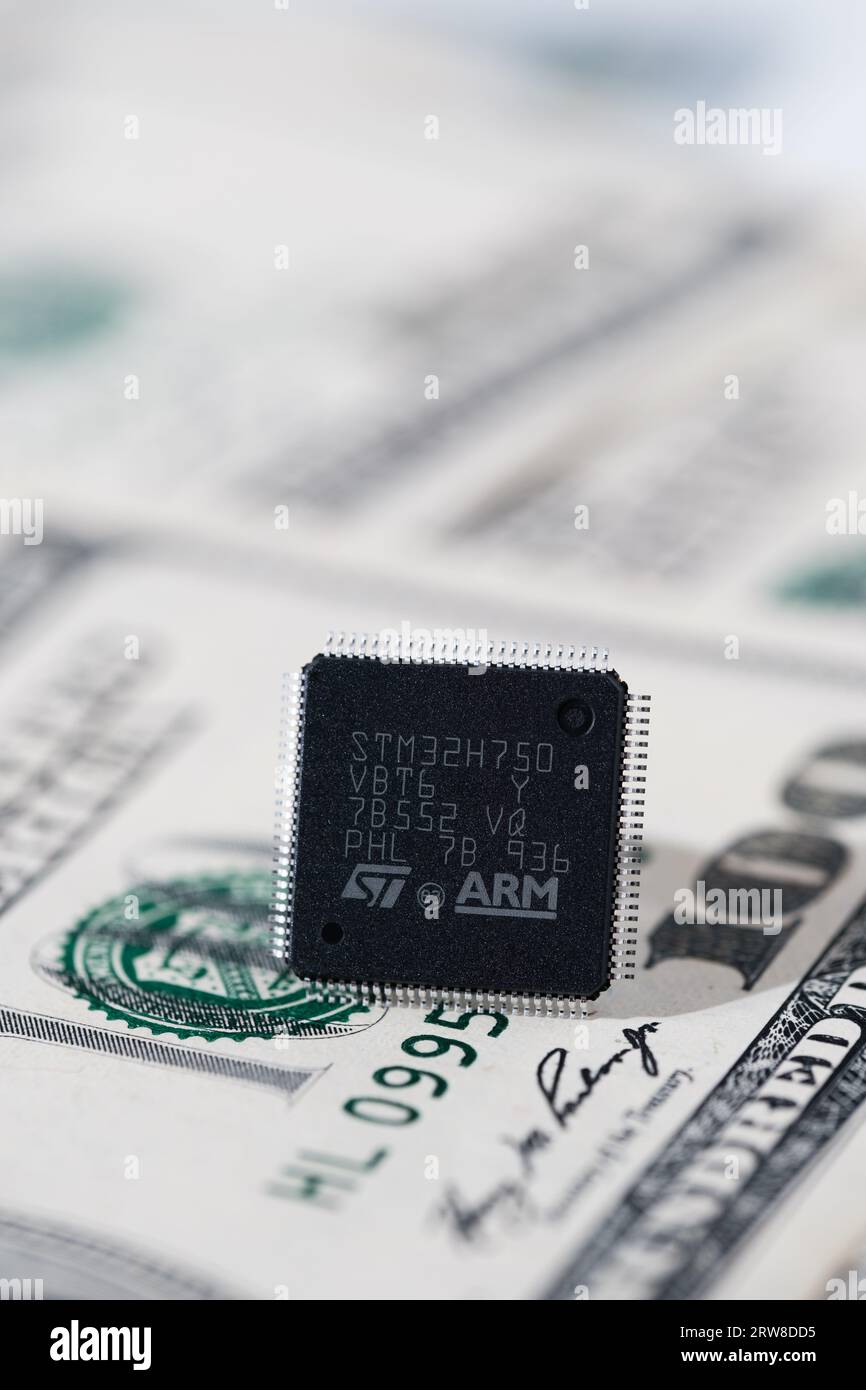 ARM ST32 chip placed on 100 USD banknote. Concept. Selective focus. London, United Kingdom, September 17, 2023 Stock Photo