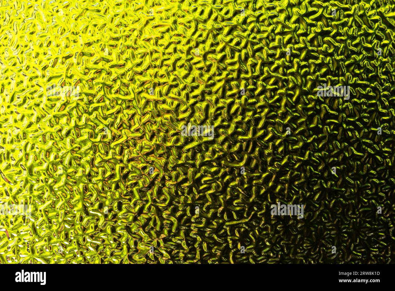 Close-up abstraction of textured green and yellow window glass. Stock Photo