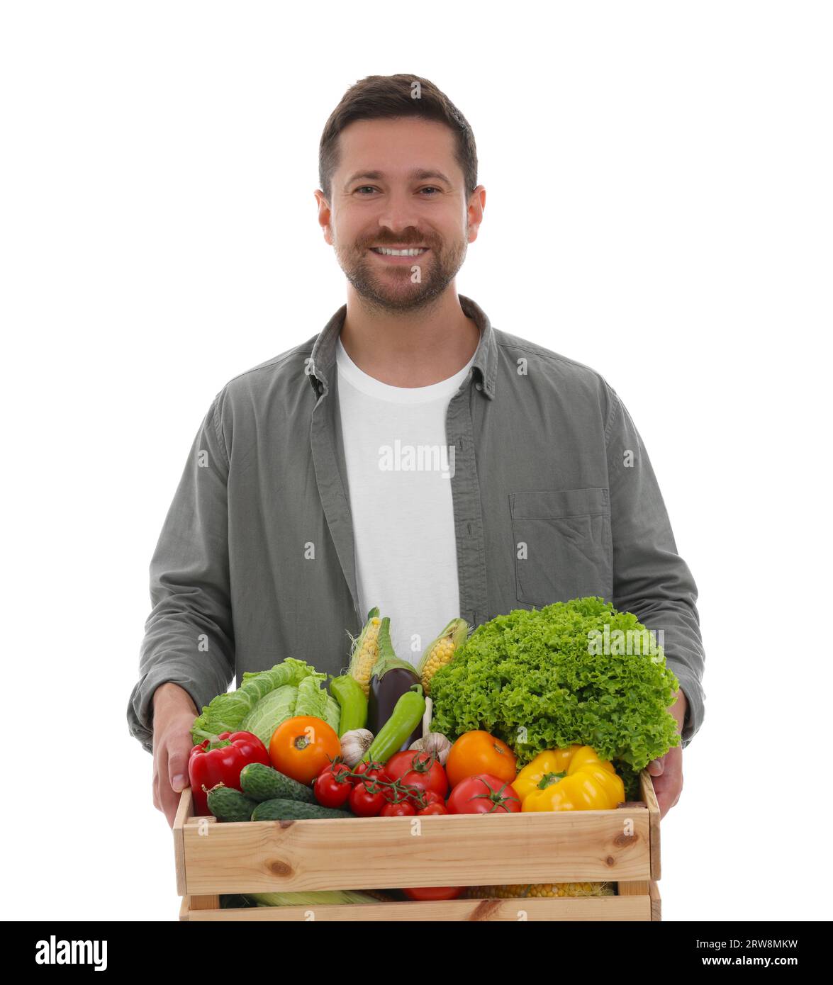 Harvesting season. Happy farmer holding wooden crate with vegetables on ...