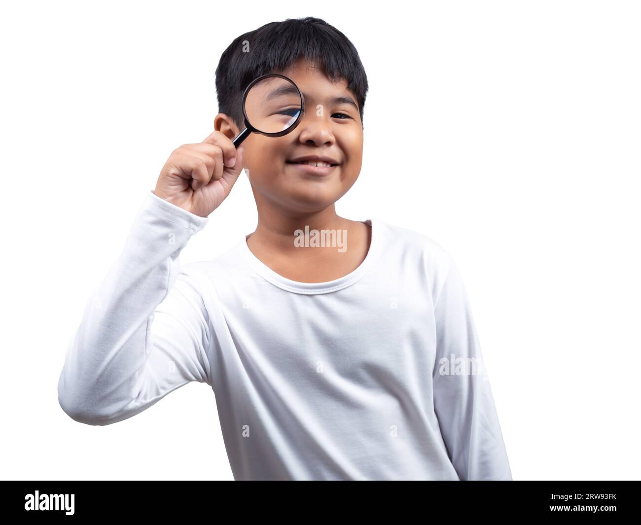 A boy wearing a white longsleeved shirt is holding a magnifying glass