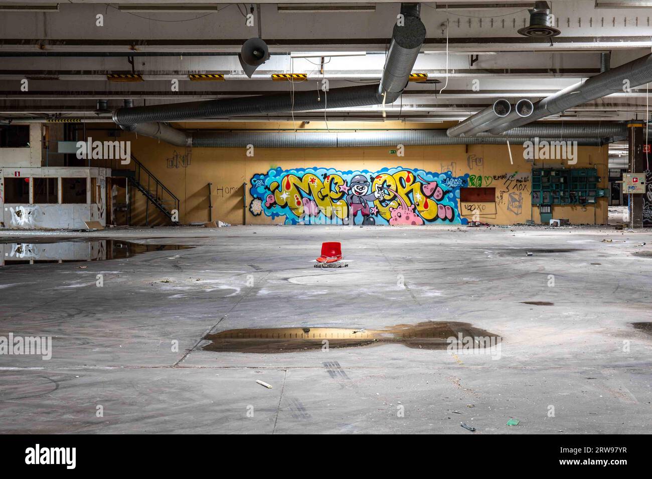 Abandoned industrial building with water on the floor and graffiti on the wall in Paimio, Finland Stock Photo