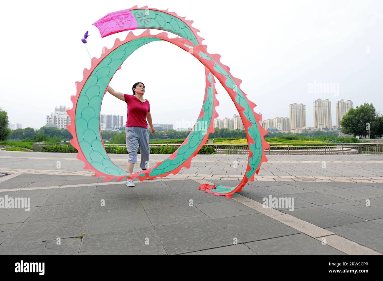LUANNAN COUNTY, Hebei Province, China - August 6, 2019: People are dancing colorful silk and exercising in the park square. Stock Photo