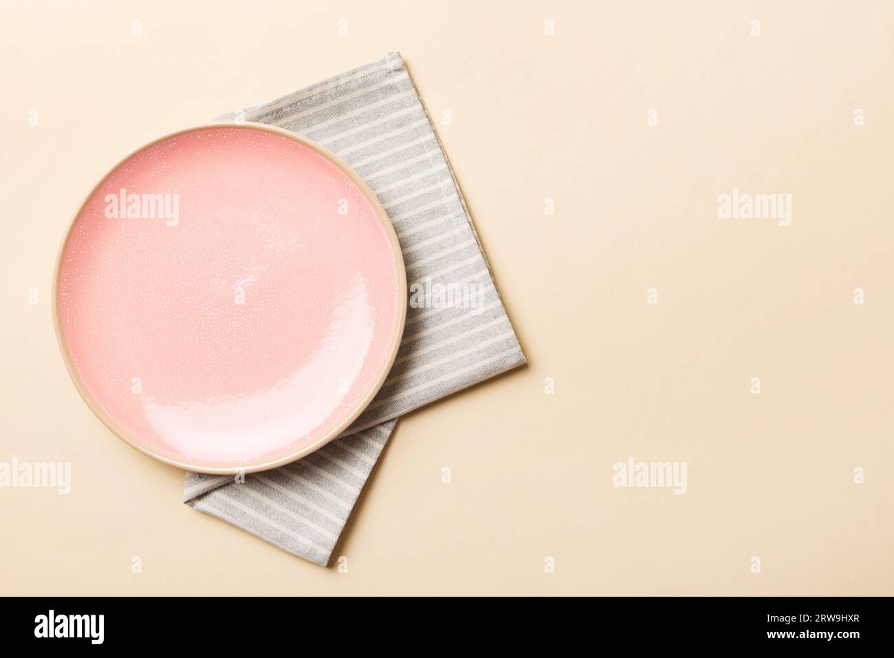 Top view on colored background empty round pink plate on tablecloth for ...