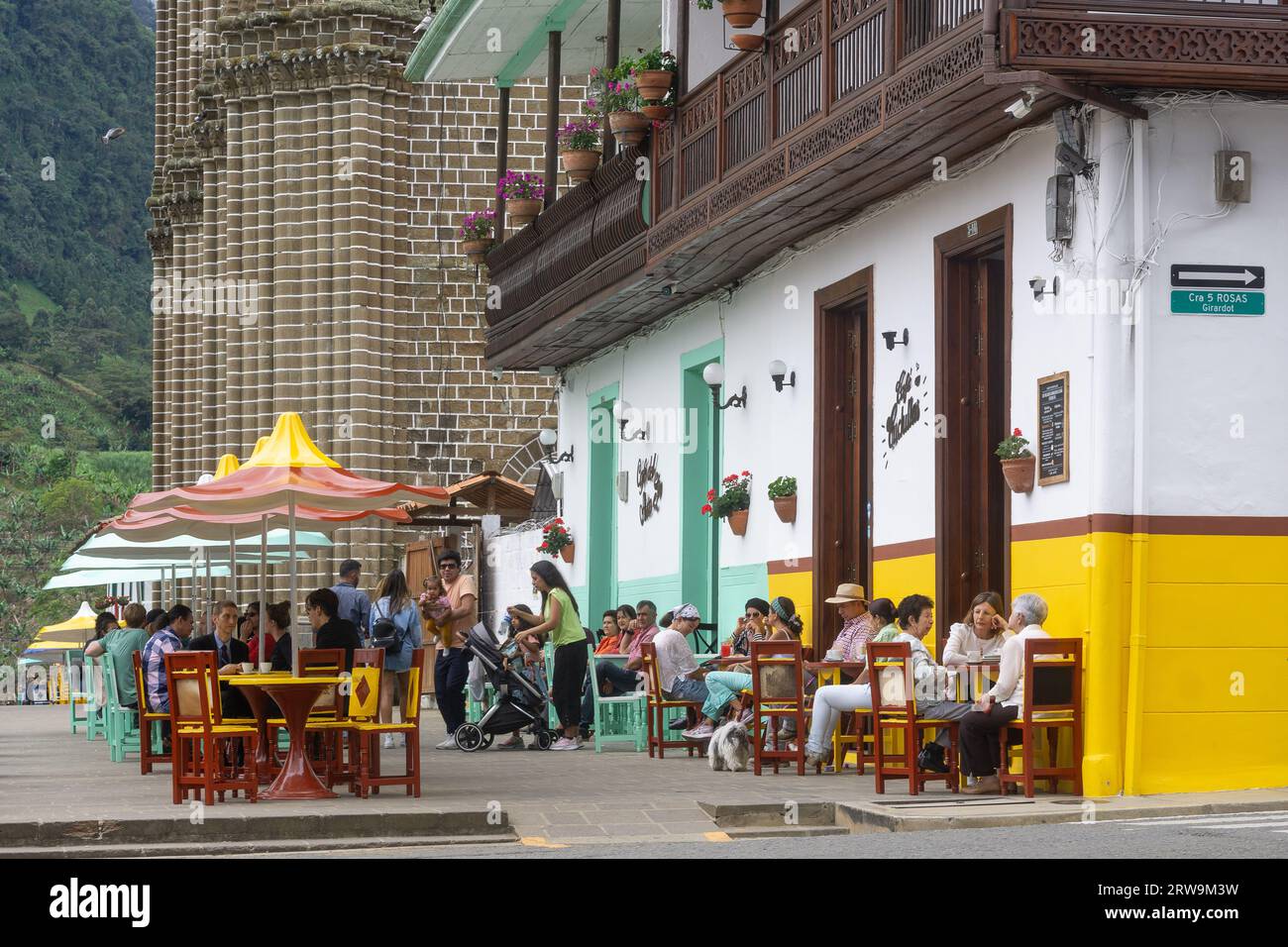 People enjoying in a cafe at the main square (El Parque El Libertador) in the village of Jardin, Antioquia, Colombia. Stock Photo