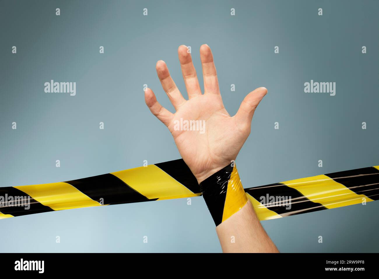 Hand tangled in yellow and black barrier tape Stock Photo