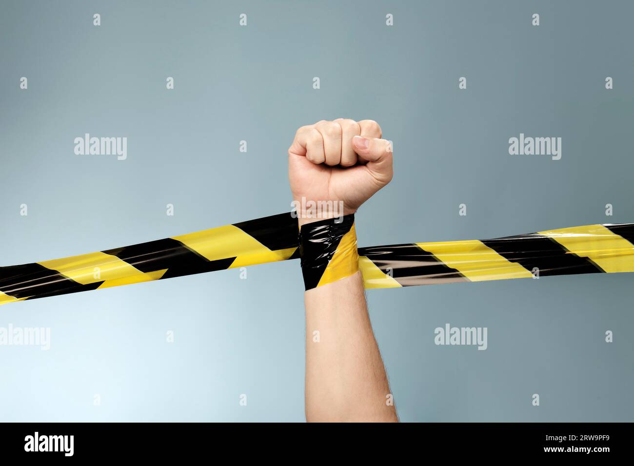 Hand tangled in black and yellow barrier tape Stock Photo