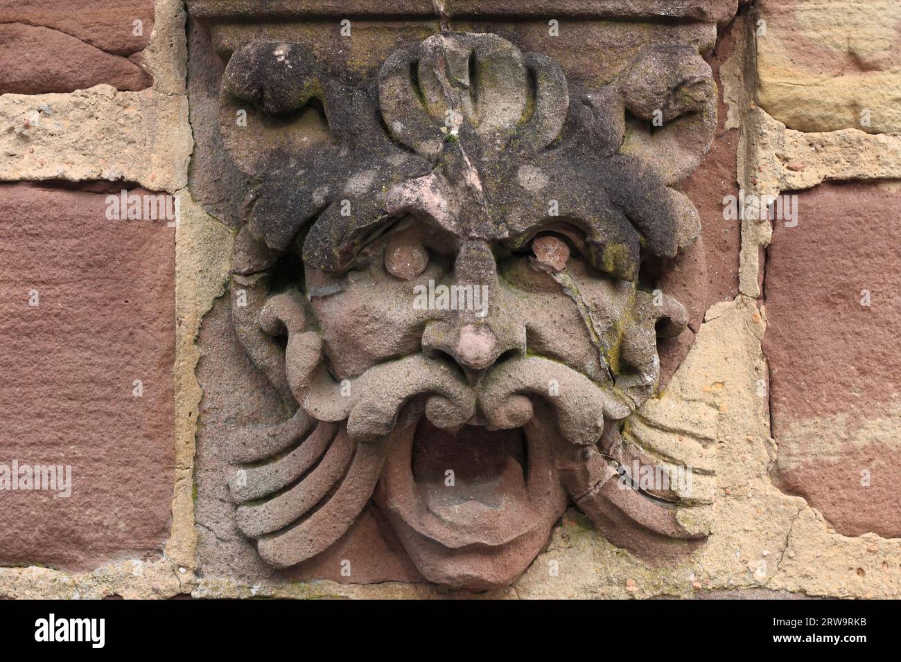 Fantasy figure on a house wall, background wall stones Stock Photo