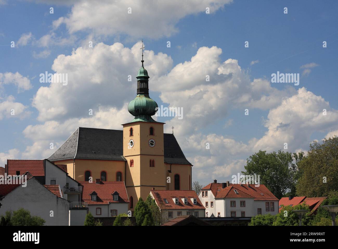 View of the Saarland baroque church of St. Stephan in Illingen, residential houses in the foreground, blue-white sky in the background Stock Photo